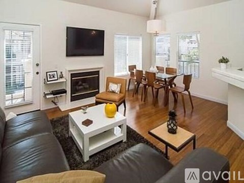 A living room with a fireplace and a television mounted on the wall.