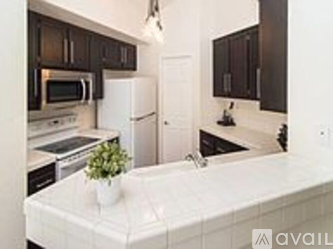 A kitchen with a white counter top and a white refrigerator.
