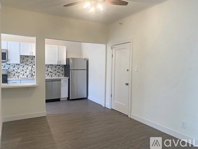 A kitchen with white cabinets and a black and white tiled backsplash.