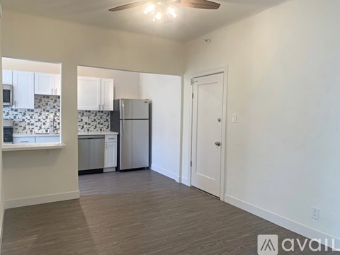 A kitchen with white cabinets and a black and white tiled backsplash.