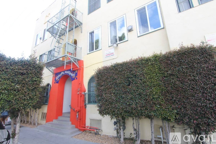 A building with a red door and a balcony with a railing.