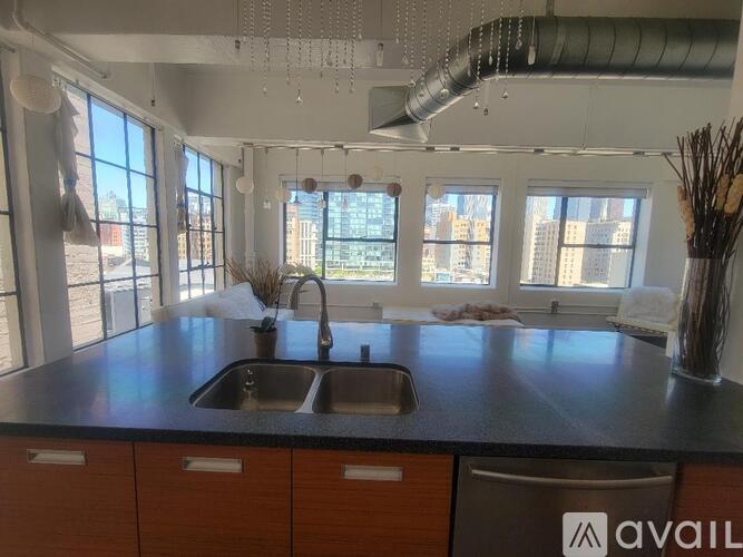 A kitchen with a black countertop and a stainless steel sink.