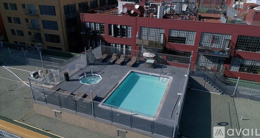 A pool on a rooftop surrounded by a fence.