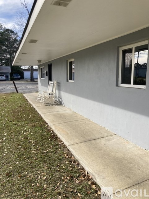 A white house with a concrete walkway in front.