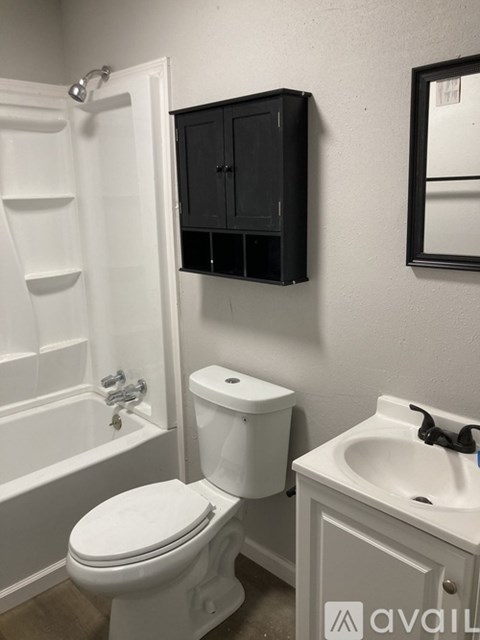 A white toilet sits next to a white sink in a bathroom.