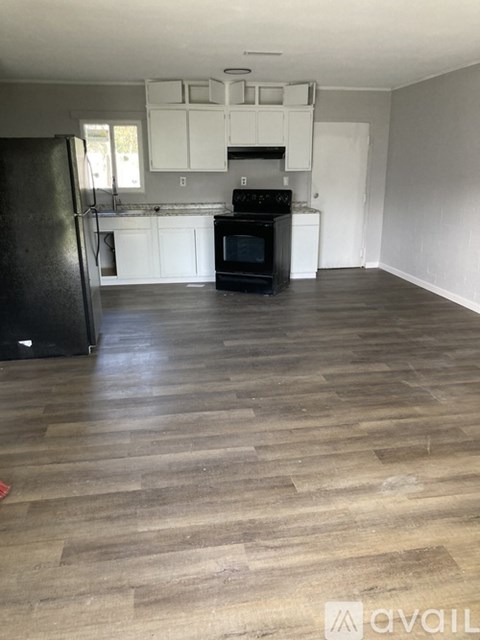 A kitchen with black appliances and white cabinets.