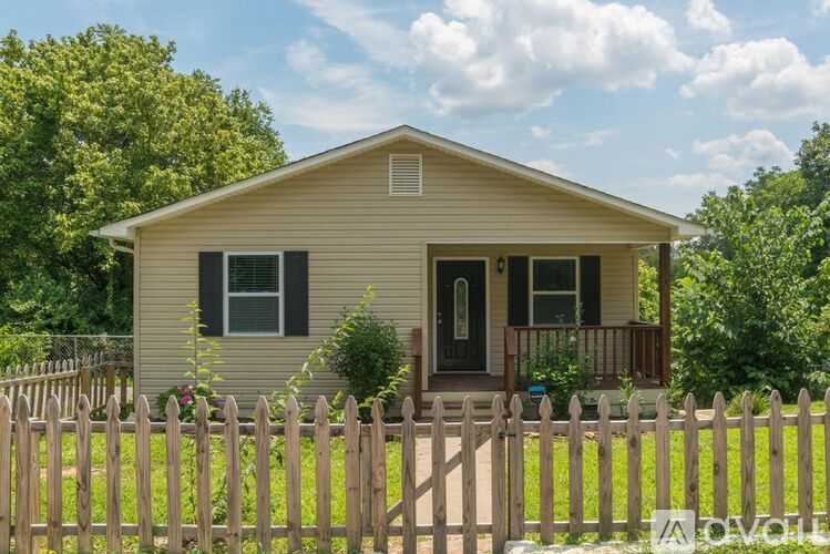 A small house with a wooden fence in front.