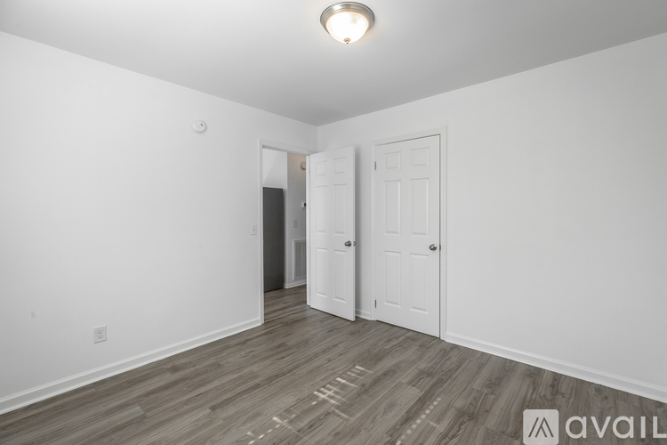 A room with a wooden floor and two white doors.