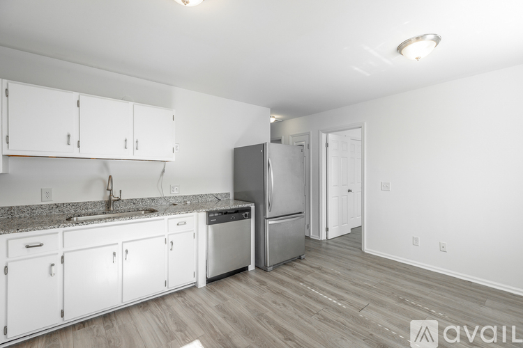 A kitchen with white cabinets and a granite countertop.