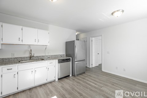 A kitchen with white cabinets and a granite countertop.