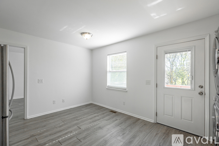 A spacious room with a door, window, and a light on the ceiling.