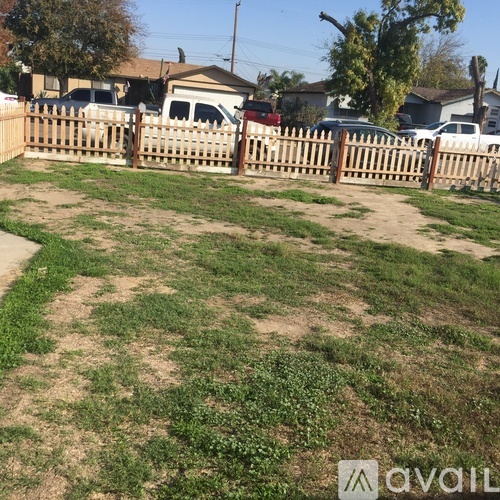 A backyard with a wooden fence and a grassy area.