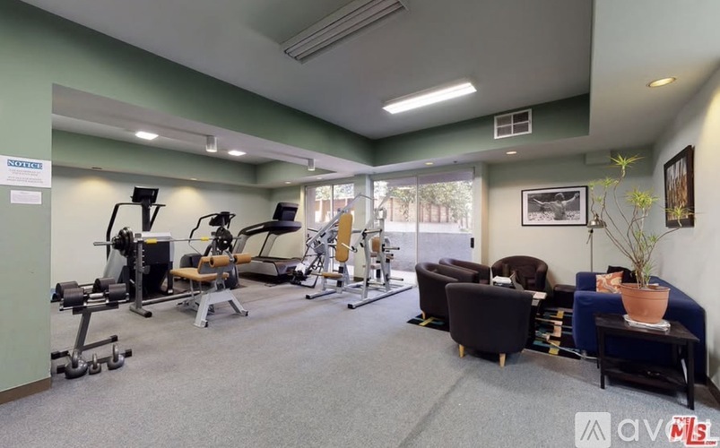 A gym with a variety of equipment including weights, a treadmill, and a stationary bike.