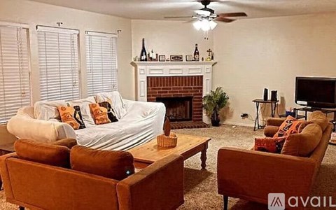 A living room with a white couch and a fireplace.