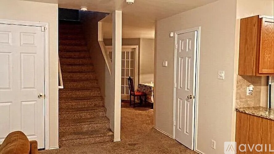 A living room with a couch and a staircase.