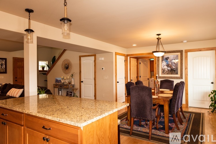 A kitchen with a dining table and chairs.