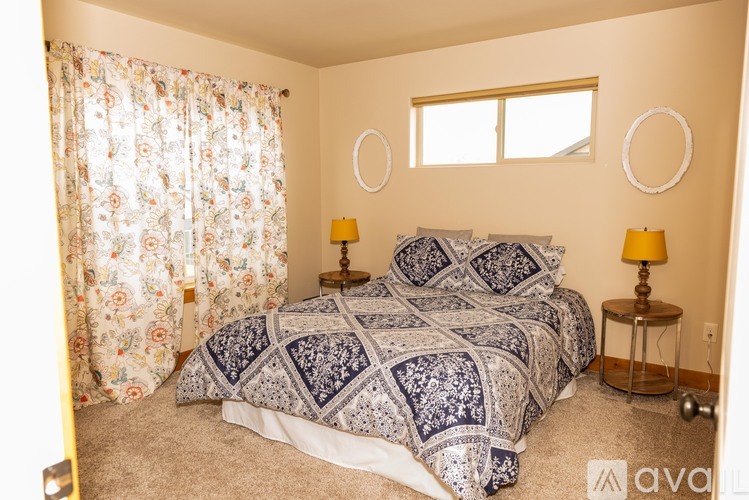 A bedroom with a large bed and two lamps.