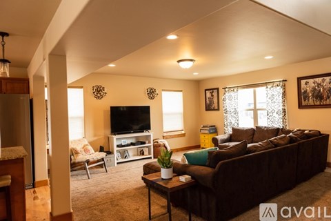 A living room with a brown couch and a television.
