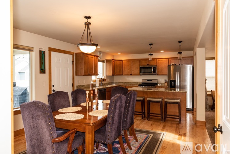 A dining room with a wooden table and chairs.