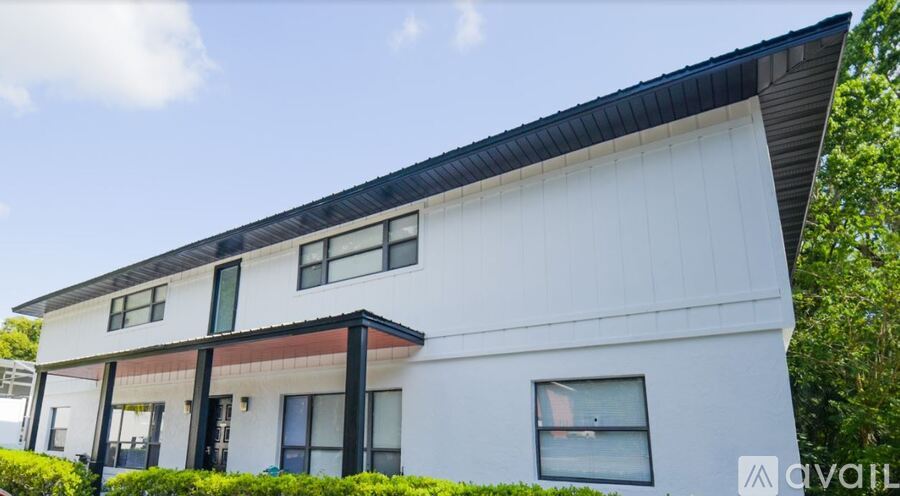 A modern white house with black trim and a balcony.