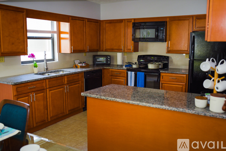 A kitchen with wooden cabinets and a granite countertop.