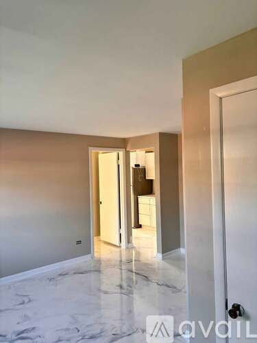 A room with marble flooring and a white door.