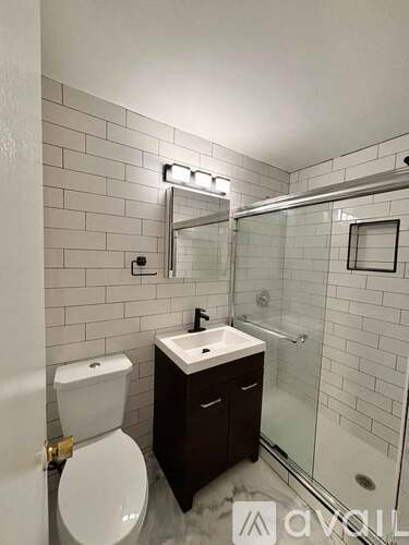 A white toilet sits next to a sink in a small bathroom.