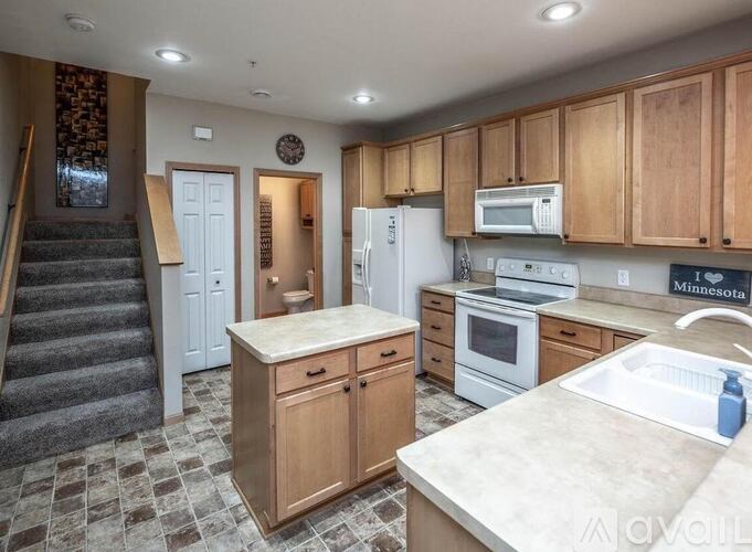 A kitchen with wooden cabinets and a tiled floor.