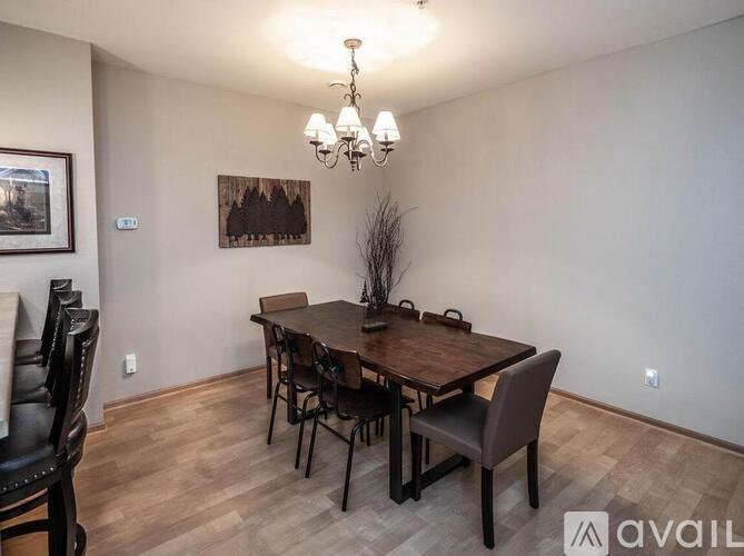 A dining room with a wooden table and chairs.