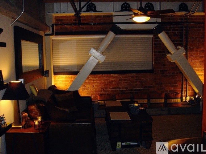 A living room with a couch, a table, and a lamp.