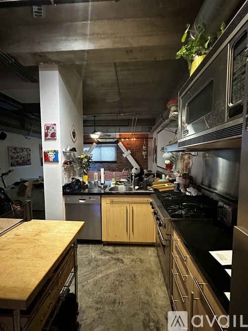 A kitchen with a wooden table and stainless steel appliances.