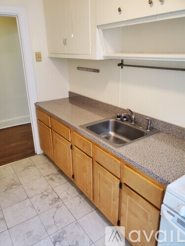 A kitchen with a sink and wooden cabinets.