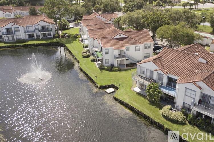 A fountain in the middle of a body of water surrounded by houses.
