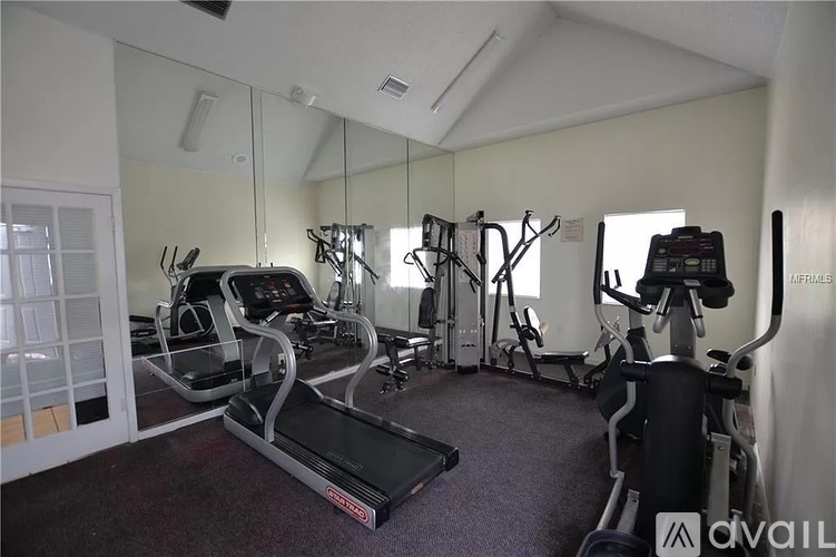 A gym with treadmills, elliptical machines, and other exercise equipment.