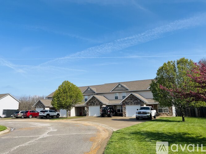 A large house with a driveway and a tree in front.
