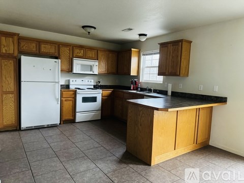 A kitchen with wooden cabinets and a white refrigerator.