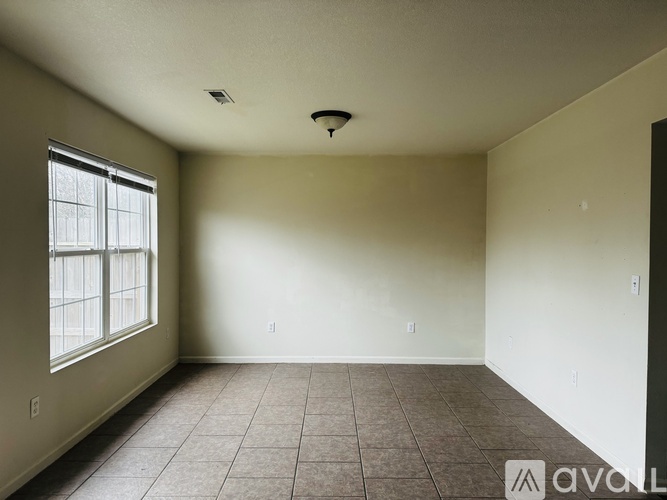 A room with a window and tiled floor.