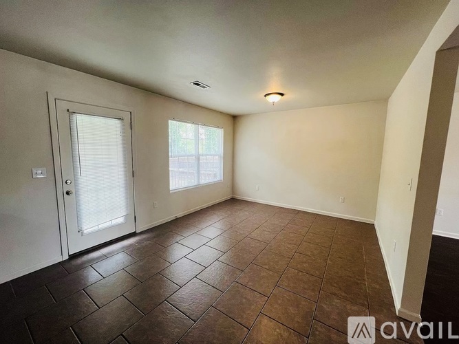 A room with brown tiles on the floor and a white door.