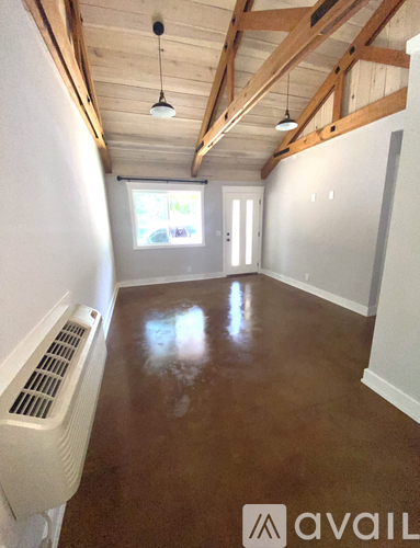 A room with wooden beams on the ceiling and a white radiator on the wall.