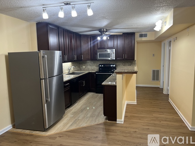 A kitchen with a refrigerator, microwave, and stove.