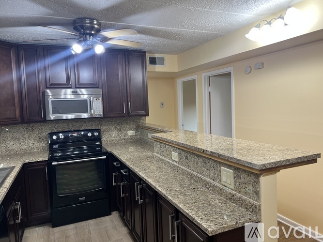 A kitchen with a black oven and a microwave above it.