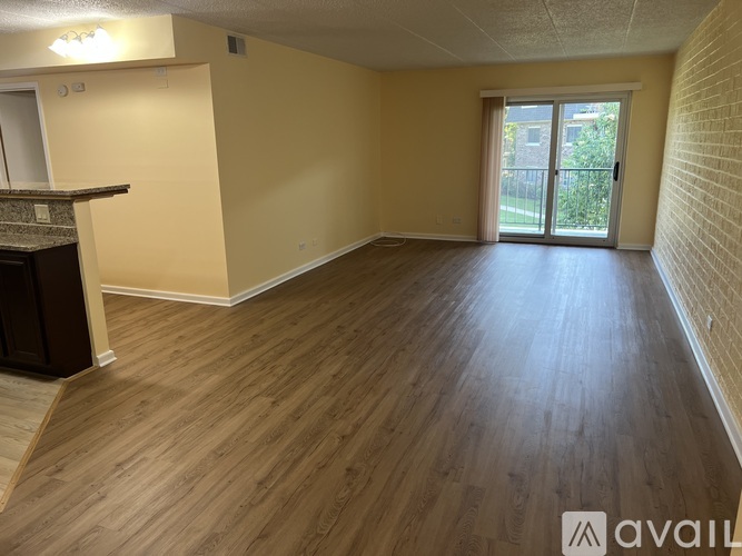 A spacious room with wooden flooring and a fireplace.