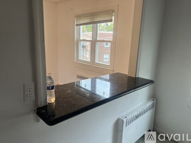 A room with a window and a radiator on a counter.