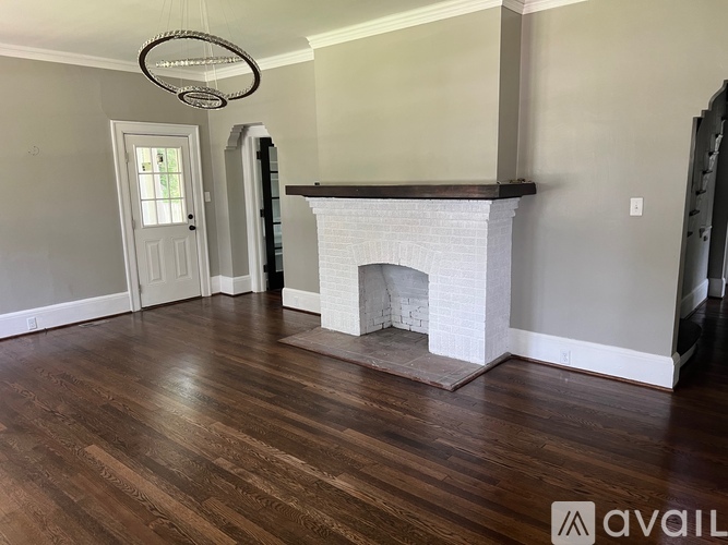 A living room with a fireplace and wood flooring.
