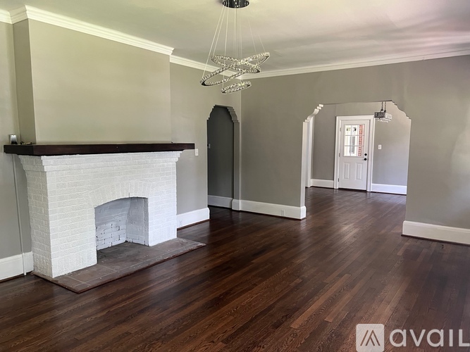 A living room with a fireplace and a chandelier.