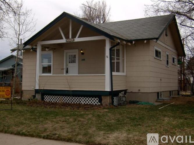 A house with a porch and a sign in front of it.