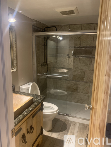 A bathroom with a toilet, sink, and shower.