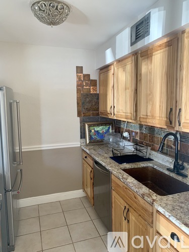 A kitchen with wooden cabinets and a granite countertop.