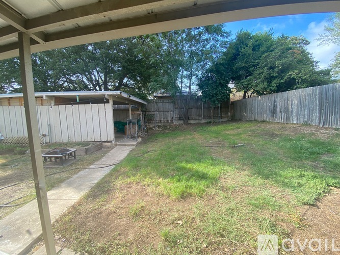 A backyard with a wooden fence and a shed.