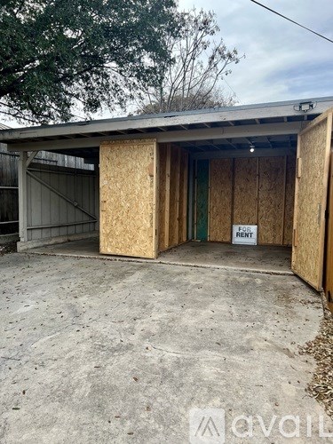 A boarded up garage with a "For Rent" sign.